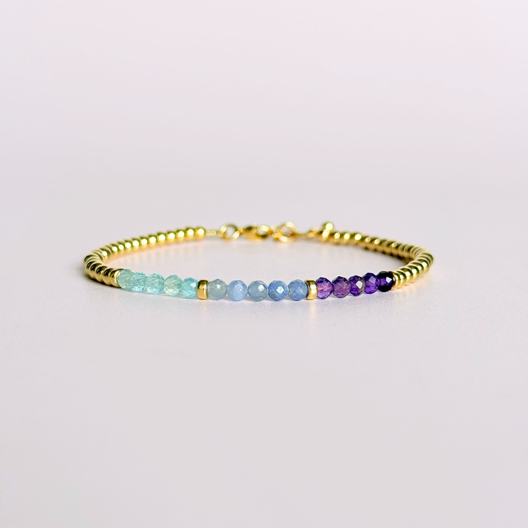 Dainty minimalist yellow gold filled crystal bracelet featuring 3mm faceted amethyst, aquamarine and tanzanite beads in a colour block Ombre style. Fastens with a gold filled lobster clasp with an extender chain.