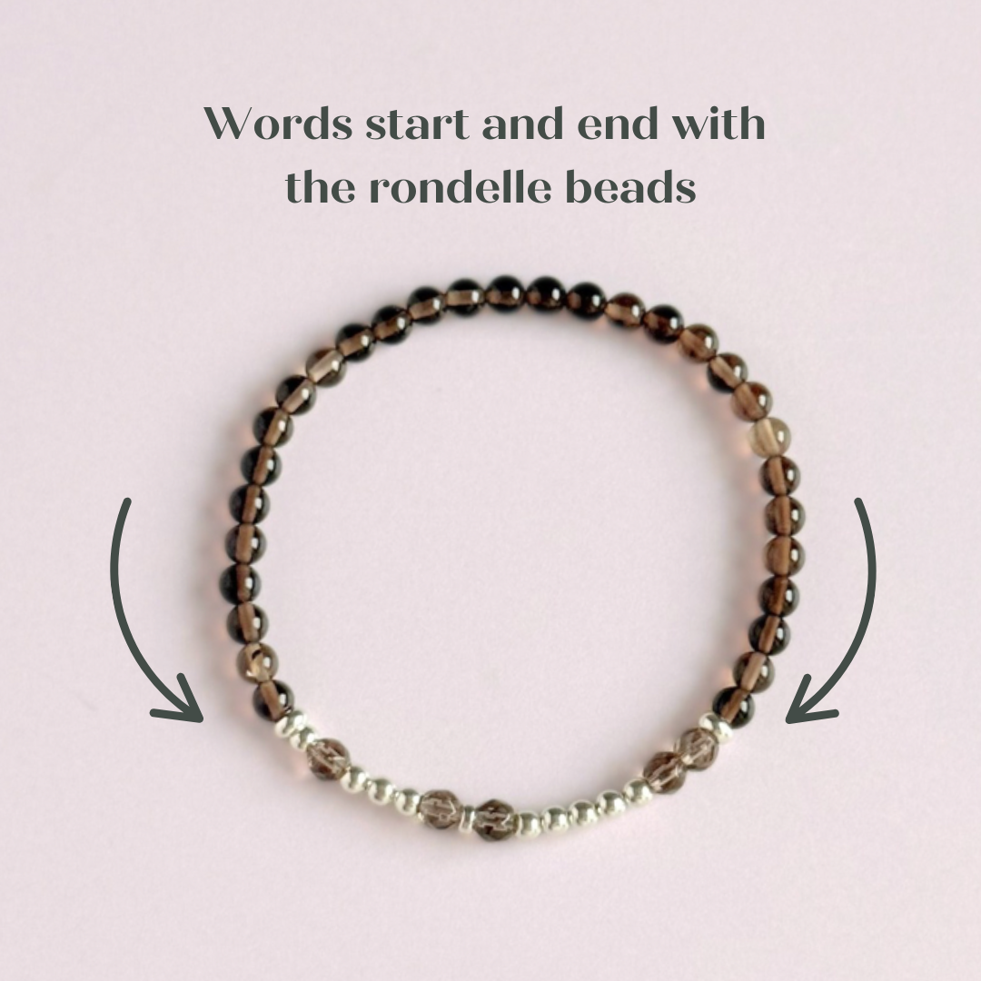 Elasticated smoky quartz crystal morse code bracelet that spells out the words ‘Let them’ in a combination of 4mm round smoky quartz beads, 4mm faceted smoky quartz beads and either sterling silver or gold vermeil 3mm round beads. The words start and end at the rondelle spacer beads.