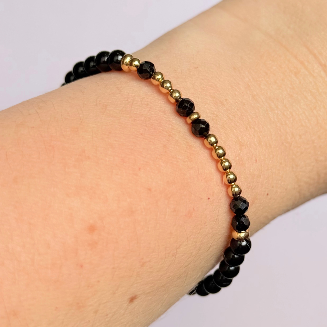 Black tourmaline crystal morse code bracelet that spells out the words ‘Let them’ in a combination of 4mm round black tourmaline beads, 4mm faceted black tourmaline beads and either sterling silver or gold vermeil 3mm round beads. The words start and end at the rondelle spacer beads.