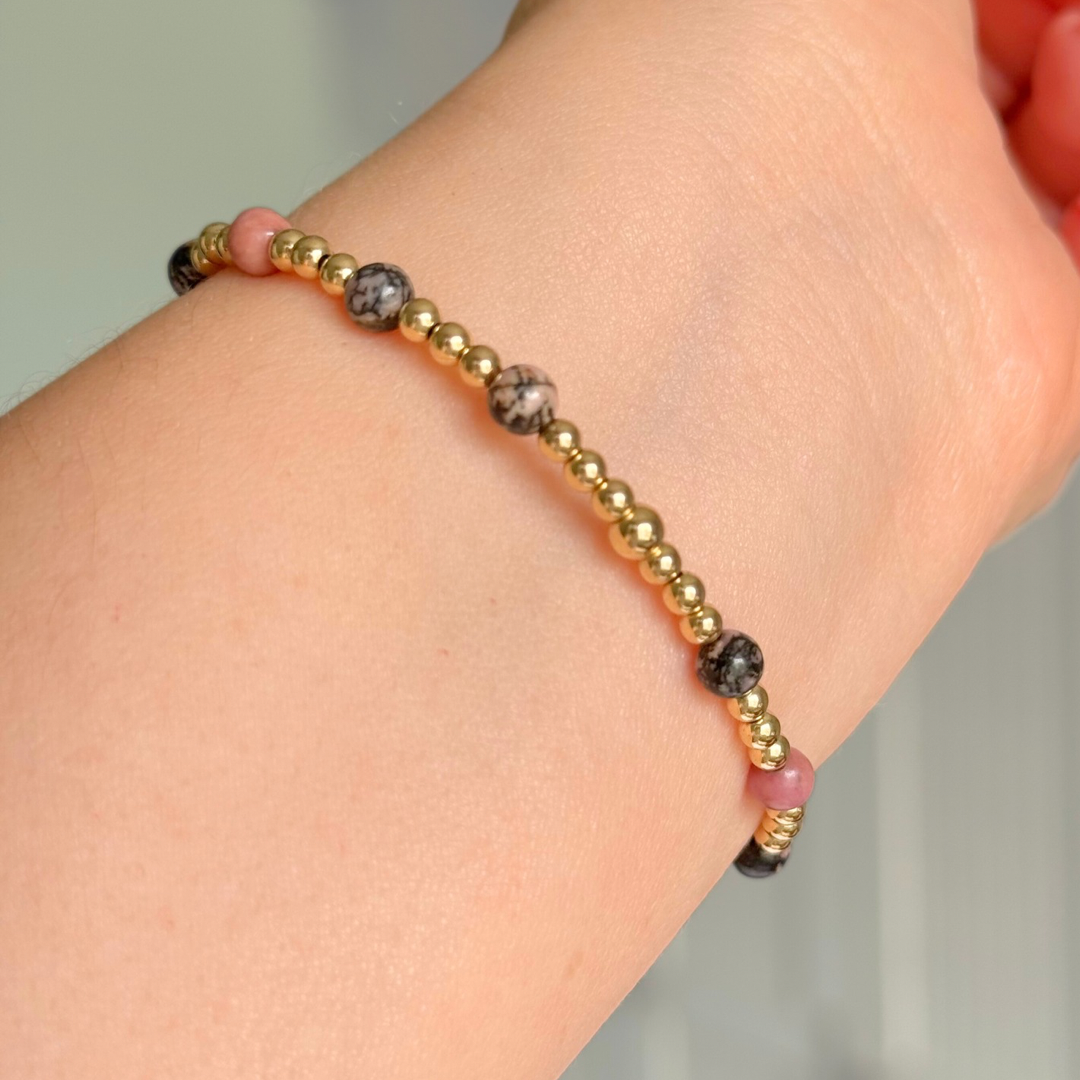 Gold filled bracelet featuring ethically mined 4mm rhodonite crystal beads, separated by 3mm gold filled beads. It features an 11mm gold filled disc charm, which is engraved with a love heart and paw design, which can be personalised with your pet's name. The reverse of the charm says 'Forever in your heart x', although this side can also be personalised with your own words.