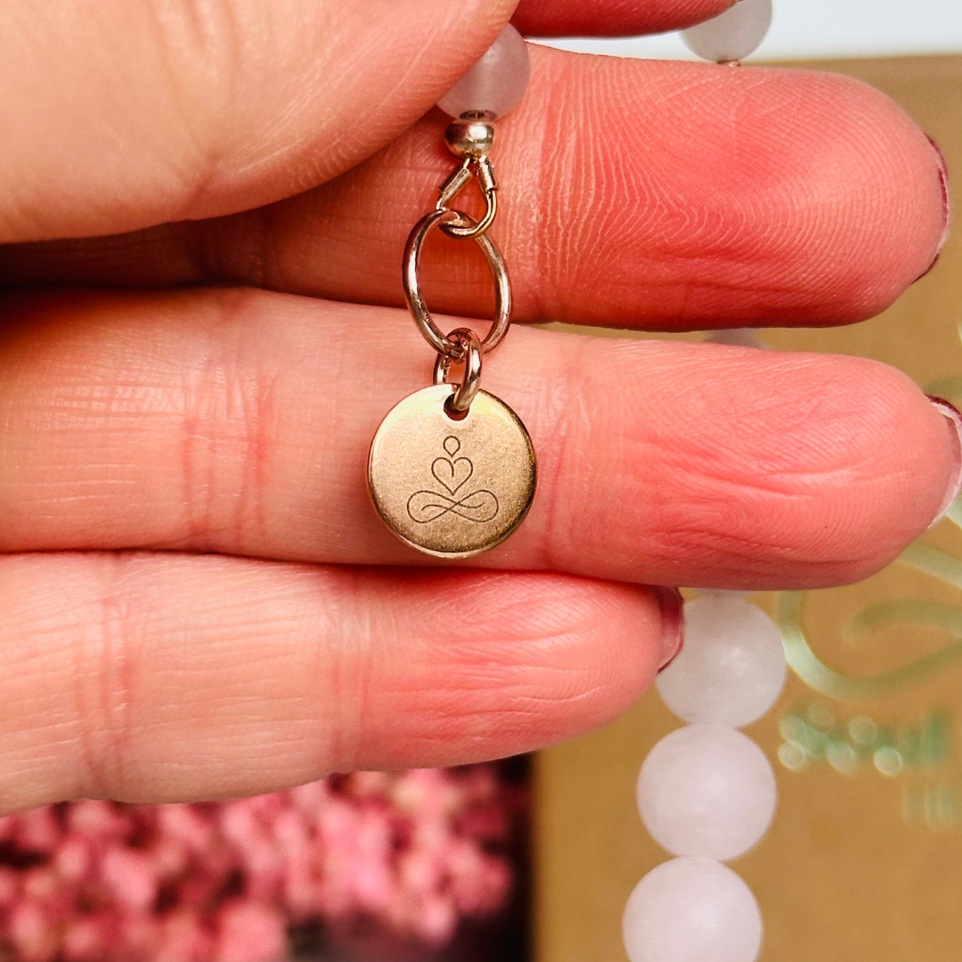 Frosted rose quartz breath work beads on a rose gold keychain/bag charm. For the 4-7-8 counted breathing method.
