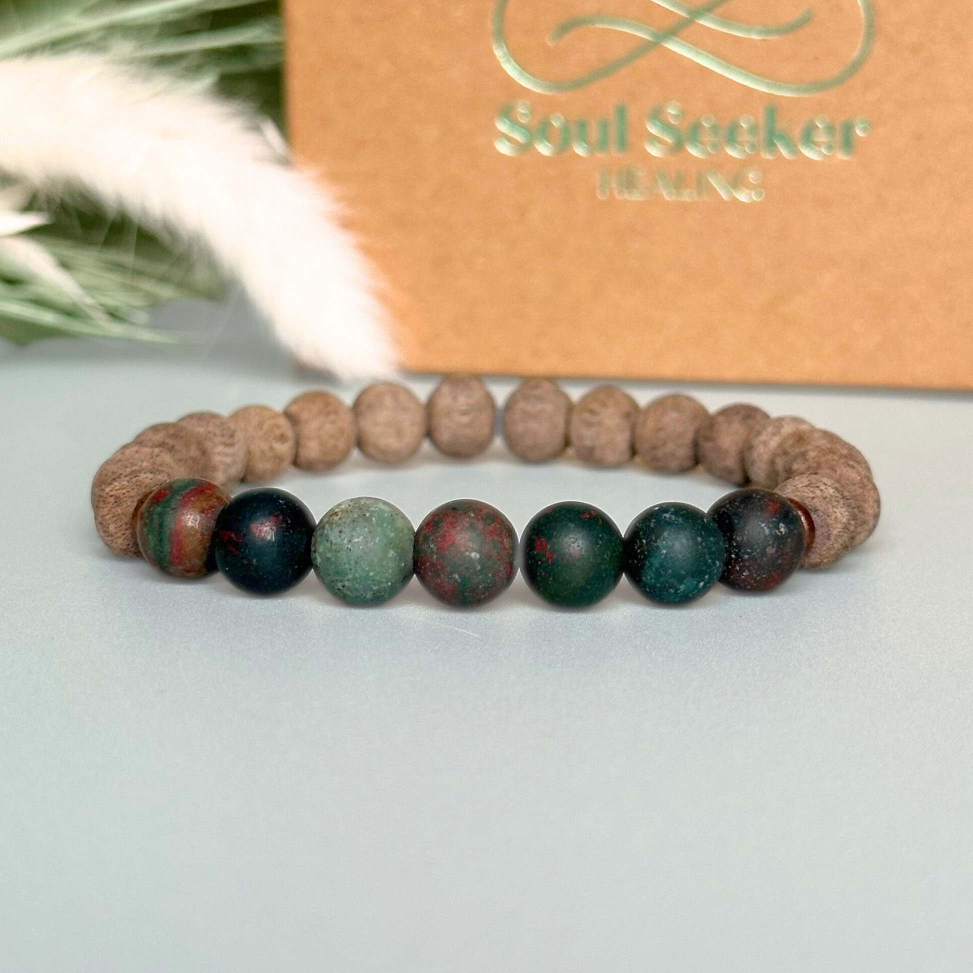 Men’s crystal bracelet featuring 8mm matte bloodstone beads, 8mm raw greywood beads with sandalwood spacer beads.