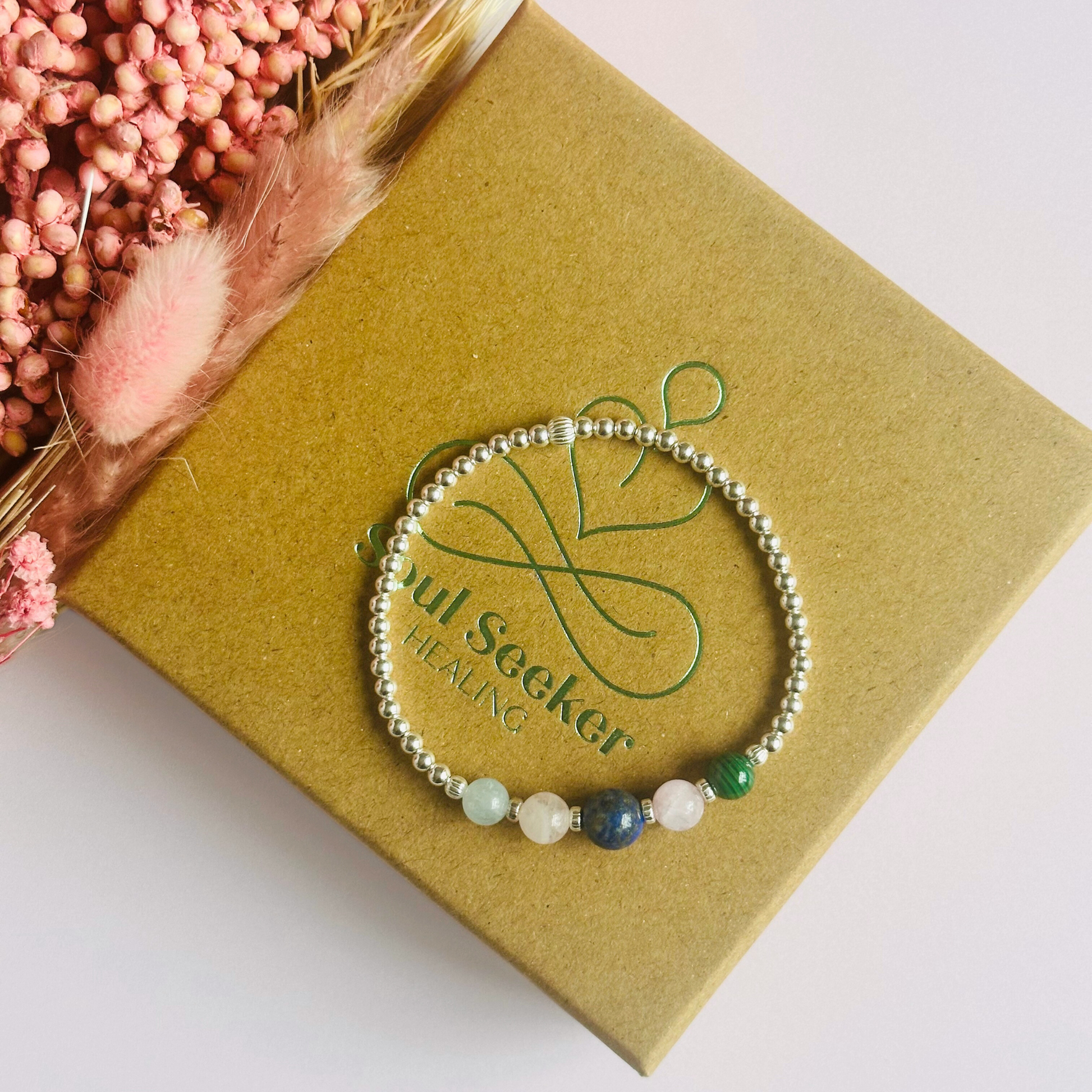 This sterling silver Taurus bracelet is made with a selection of five healing crystals all believed to resonate with the Taurus zodiac sign. The central bead is 8mm, the other four are 6mm. On an elasticated band of 3mm sterling silver beads with corrugated accent beads. Featuring malachite, lapis lazuli, rose quartz, kunzite and aquamarine.