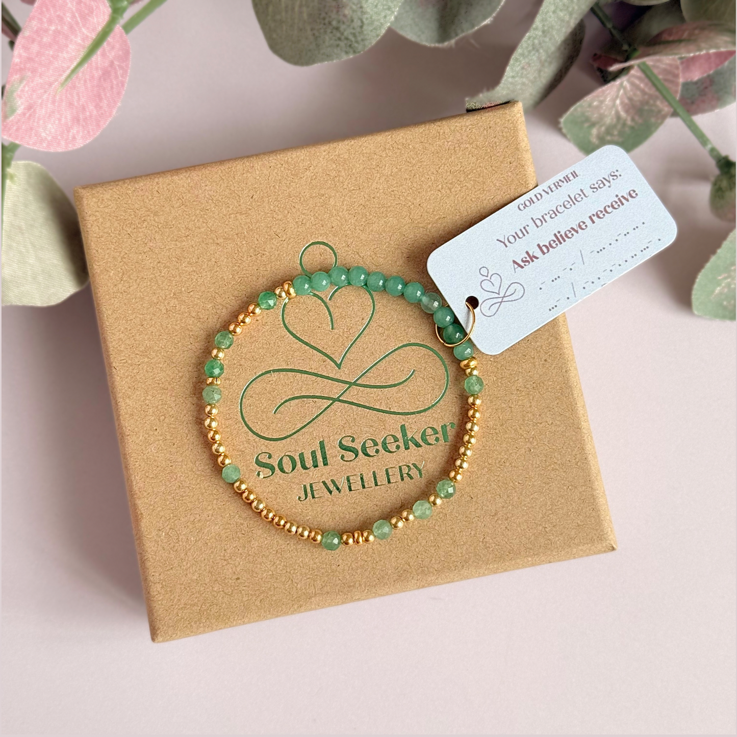 Green aventurine morse code bracelet that spells out the words ‘Ask, believe, receive’ in a combination of 4mm round smooth and faceted crystal beads with your choice of sterling silver or gold vermeil accent beads. Pictured in gold, on the gift box