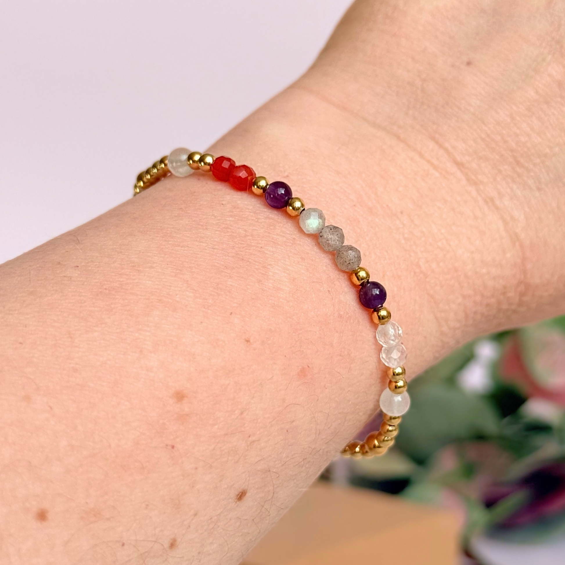 Dainty gold vermeil crystal bracelet featuring five crystals, in 4mm faceted and smooth round style, each believed to help with hormonal balance. Featuring amethyst, moonstone, carnelian, labradorite and rose quartz. Pictured being worn.