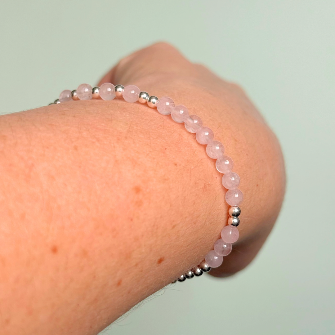 Morse code secret message bracelet spelling out the words Mum est. 2025 in sterling silver and rose quartz crystal beads. elasticated with 4mm rose quartz beads and 3mm sterling silver beads.