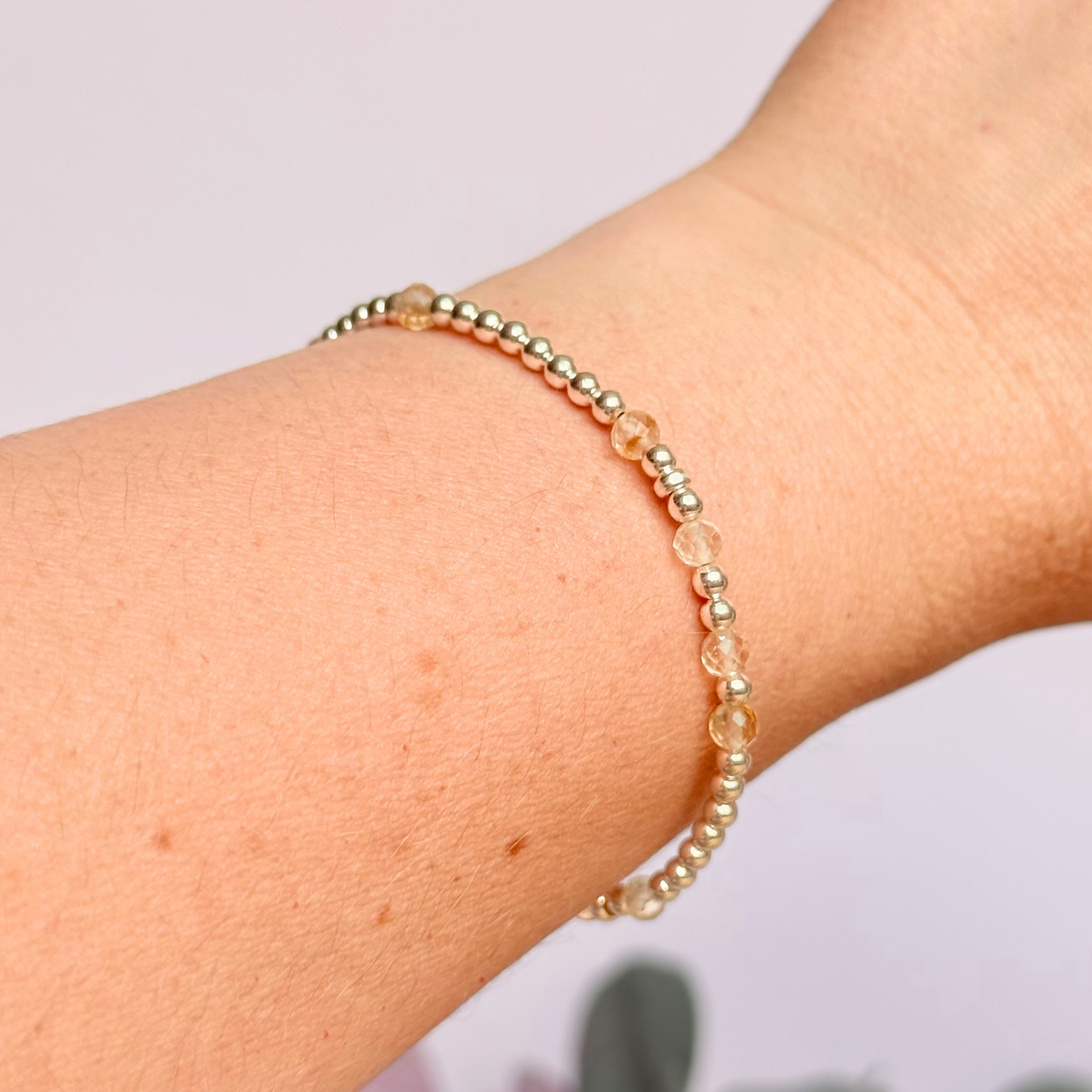 Citrine morse code bracelet that spells out the words ‘Ask, believe, receive’ in a combination of 4mm round smooth and faceted crystal beads with your choice of sterling silver or gold vermeil accent beads. Shown in silver, being worn.