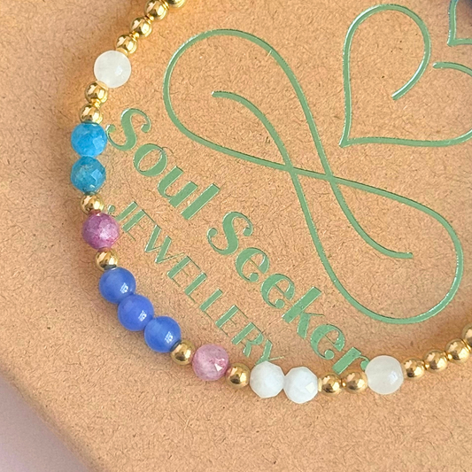 ‘Santorini' gold vermeil dainty beaded bracelet with pink tourmaline, rainbow moonstone, blue agate, apatite and white jade. Made with round 3mm gold vermeil beads and 4mm smooth and faceted round crystal gemstone beads. Pictured close up, on top of the box