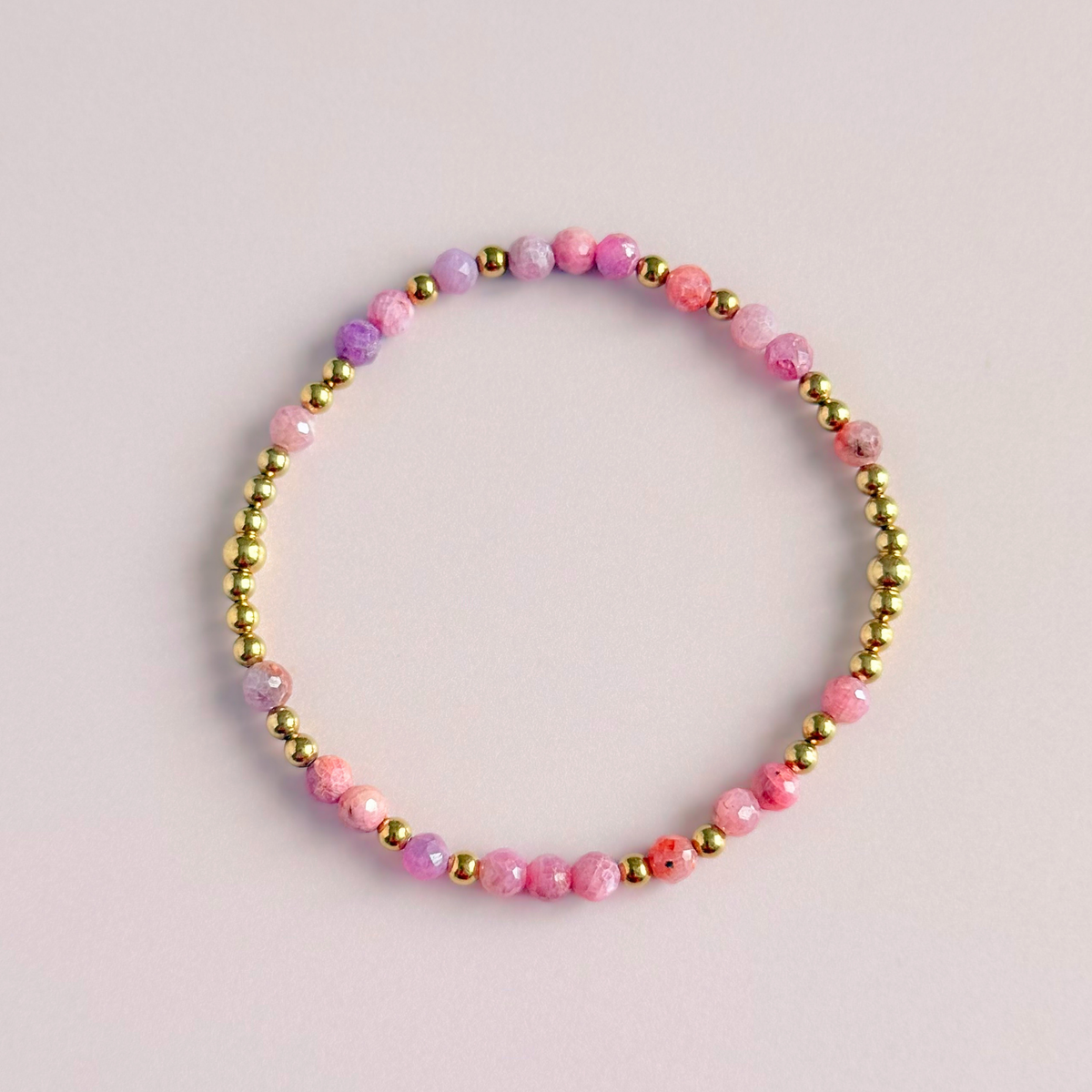 Dainty, minimalist gold vermeil and pink tourmaline October birthstone stacking bracelet. Made with 4mm faceted pink tourmaline beads and 3mm gold vermeil round beads. Elasticated for comfort. Pictured from above