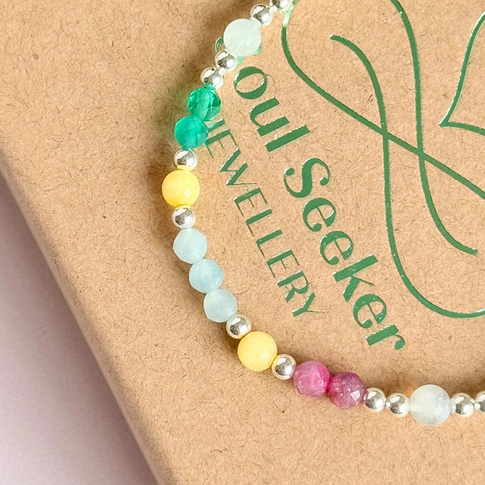 'Amalfi Coast' sterling silver dainty beaded bracelet with green agate, yellow calcite, pink tourmaline, aquamarine and moonstone. Made with round 3mm sterling silver beads and 4mm smooth and faceted round crystal gemstone beads. Pictured close up, on the bo