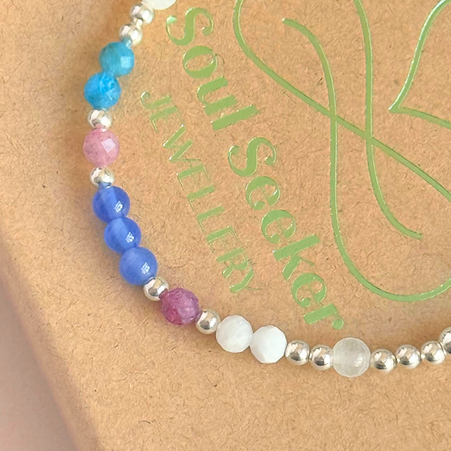 ‘Santorini' sterling silver dainty beaded bracelet with pink tourmaline, rainbow moonstone, blue agate, apatite and white jade. Made with round 3mm sterling silver beads and 4mm smooth and faceted round crystal gemstone beads. Pictured on top of the box, close up
