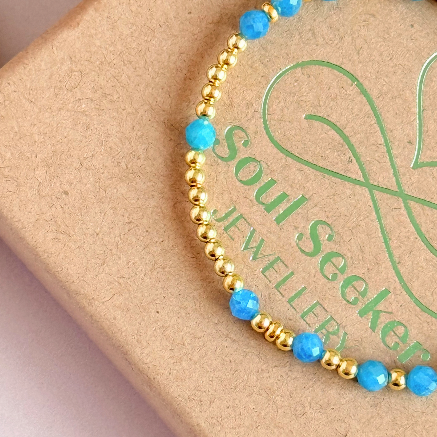 Apatite morse code bracelet that spells out the words ‘Ask, believe, receive’ in a combination of 4mm round smooth and faceted crystal beads with your choice of sterling silver or gold vermeil accent beads. Pictured in gold, close up