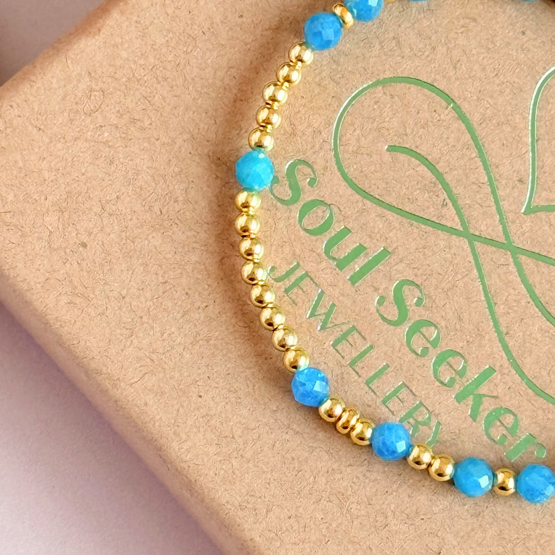 Apatite morse code bracelet that spells out the words ‘Ask, believe, receive’ in a combination of 4mm round smooth and faceted crystal beads with your choice of sterling silver or gold vermeil accent beads. Pictured in gold, close up