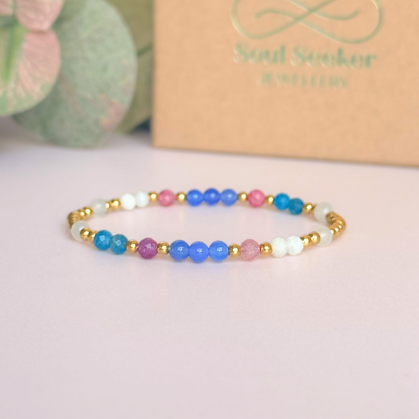 ‘Santorini' gold vermeil dainty beaded bracelet with pink tourmaline, rainbow moonstone, blue agate, apatite and white jade. Made with round 3mm gold vermeil beads and 4mm smooth and faceted round crystal gemstone beads. Pictured in front of the gift box