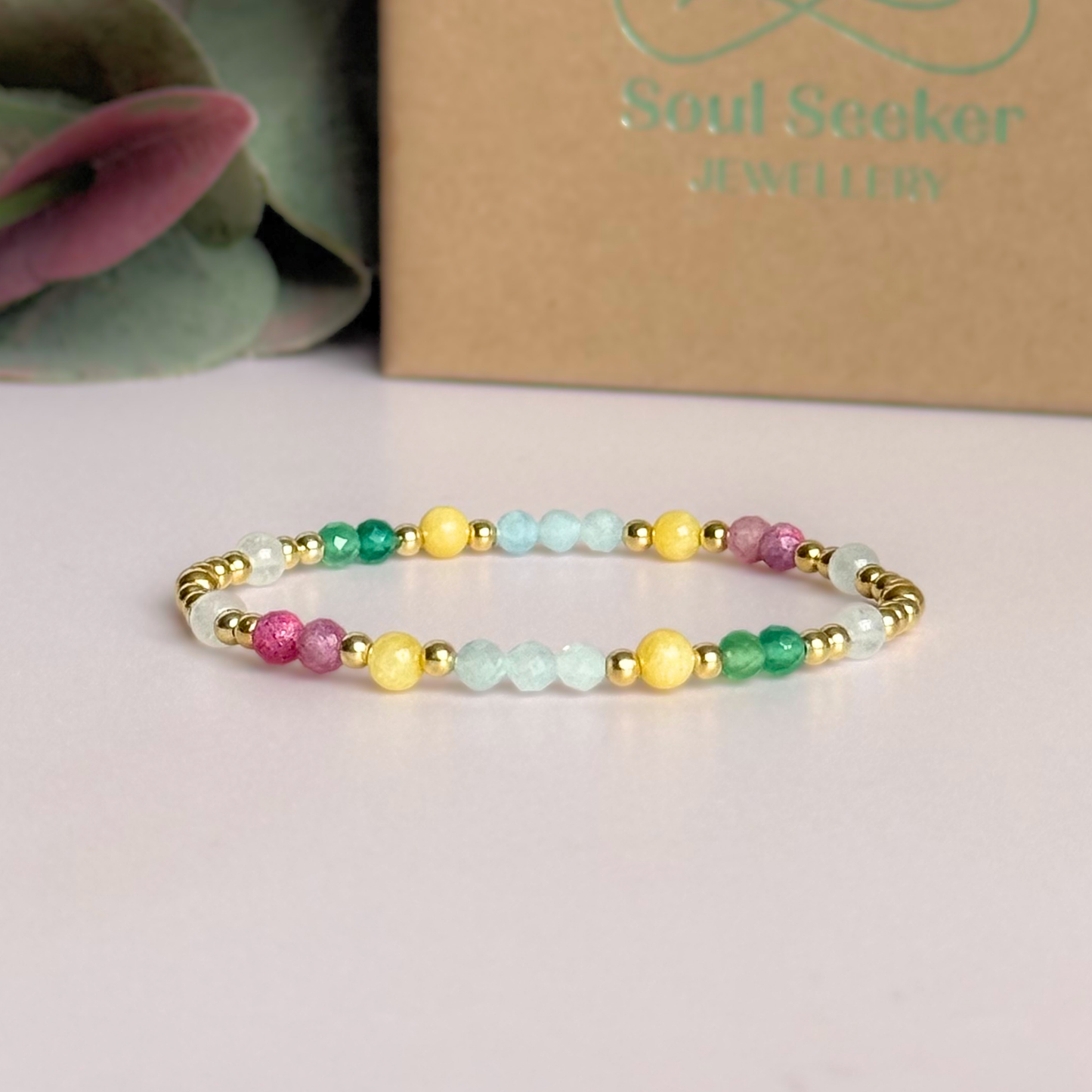 'Amalfi Coast' gold vermeil dainty beaded bracelet with green agate, yellow calcite, pink tourmaline, aquamarine and moonstone. Made with round 3mm gold vermeil beads and 4mm smooth and faceted round crystal gemstone beads. Pictured in front of the gift box
