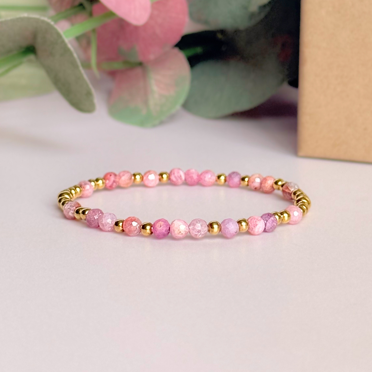 Dainty, minimalist gold vermeil and pink tourmaline October birthstone stacking bracelet. Made with 4mm faceted pink tourmaline beads and 3mm gold vermeil round beads. Elasticated for comfort. Pictured in front of the gift box