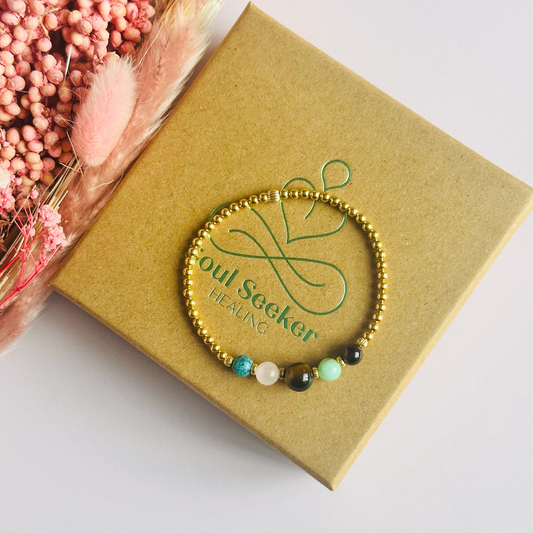 This gold vermeil Leo bracelet is made with a selection of five healing crystals all believed to resonate with the Leo zodiac sign. The central bead is 8mm, the other four are 6mm. On an elasticated band of 3mm gold vermeil beads with corrugated accent beads. Featuring chrysocolla, garnet, tigers eye, rose quartz and turquoise.