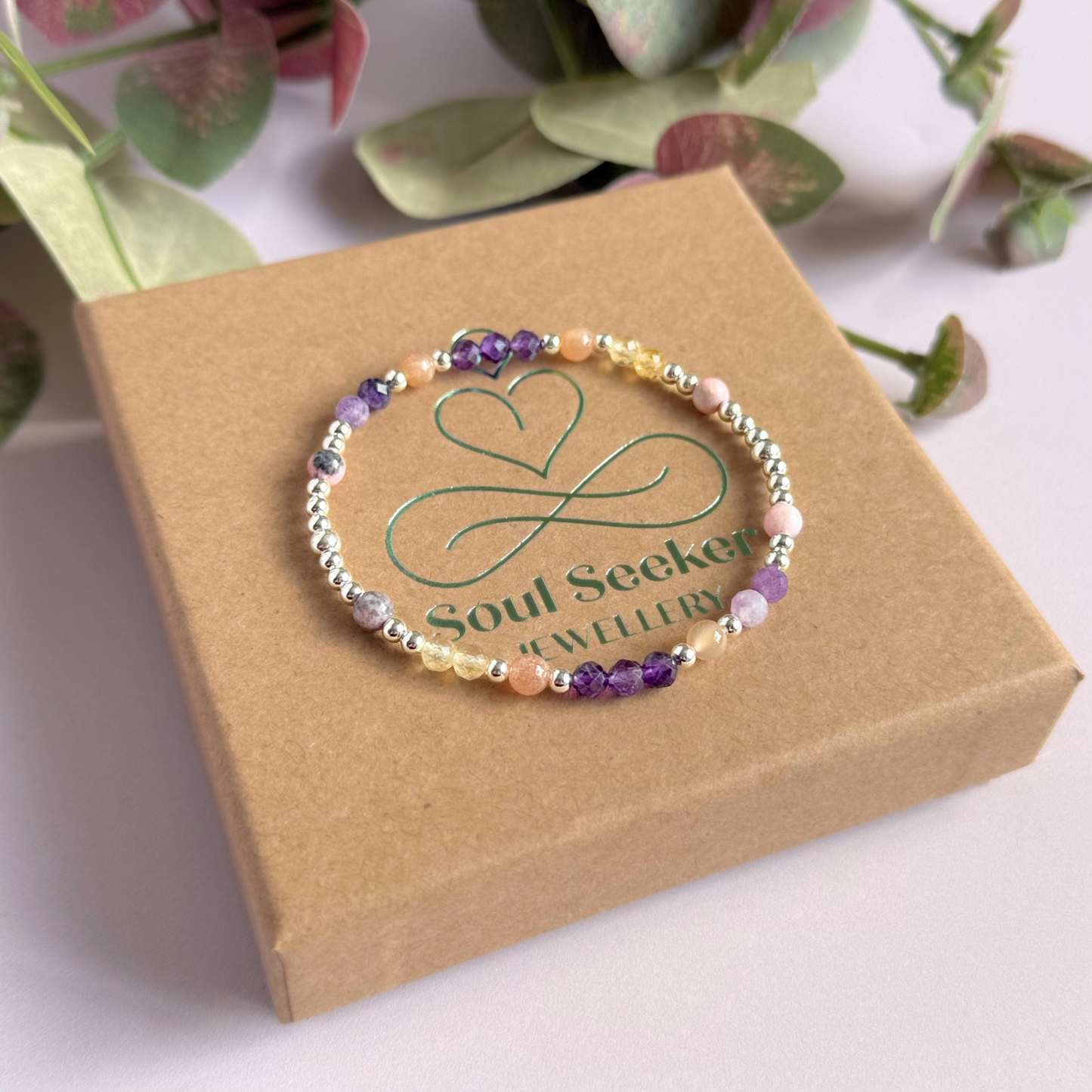 Dainty sterling silver crystal bracelet featuring five crystals, in 4mm faceted and smooth round style, each believed to help with menopause symptoms. Featuring amethyst, citrine, lepidolite, peach moonstone and pink zebra jasper. Pictured on top of the gift box.