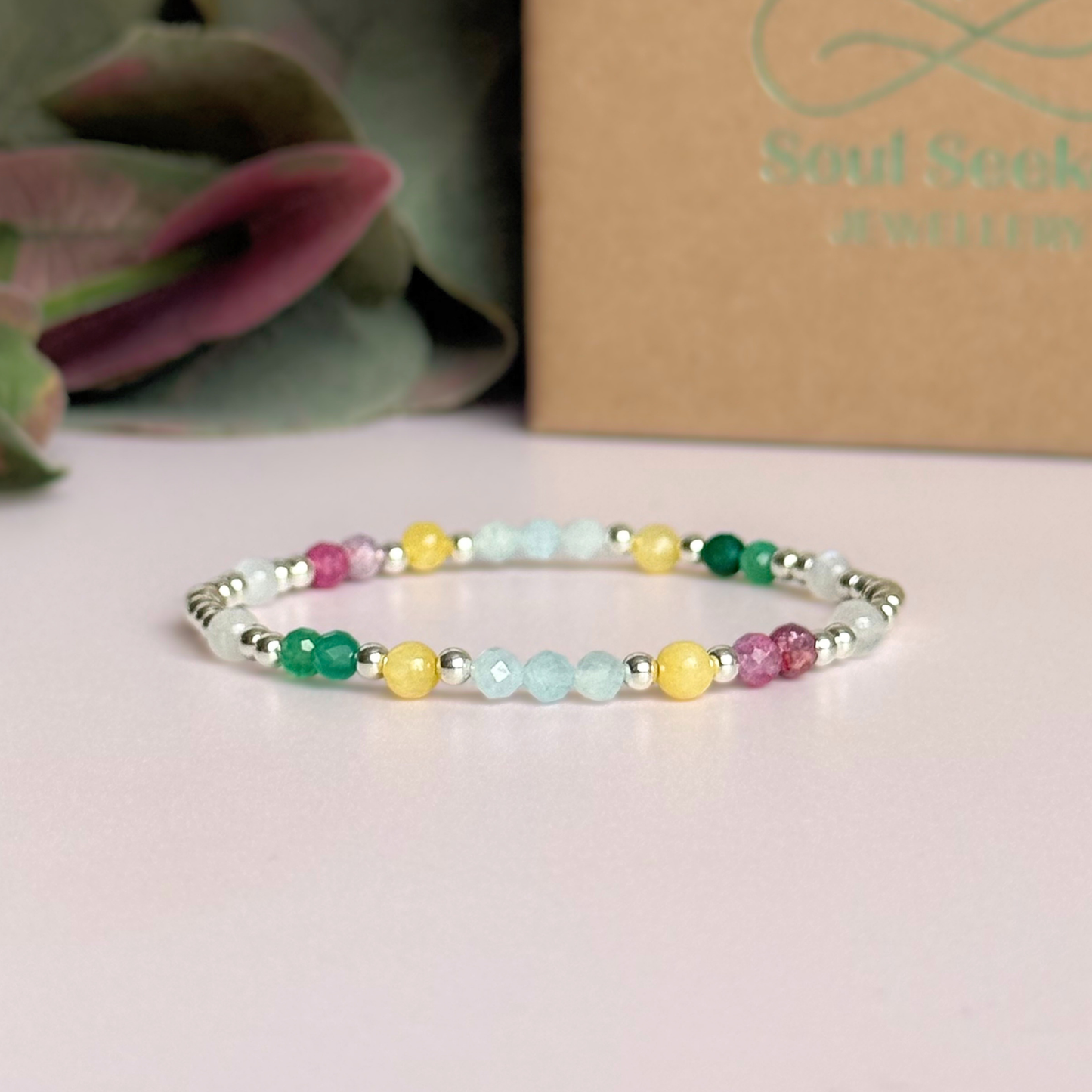 'Amalfi Coast' sterling silver dainty beaded bracelet with green agate, yellow calcite, pink tourmaline, aquamarine and moonstone. Made with round 3mm sterling silver beads and 4mm smooth and faceted round crystal gemstone beads. Pictured in front of the box