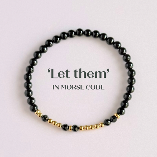 Black tourmaline crystal morse code bracelet that spells out the words ‘Let them’ in a combination of 4mm round black tourmaline beads, 4mm faceted black tourmaline beads and either sterling silver or gold vermeil 3mm round beads. The words start and end at the rondelle spacer beads.