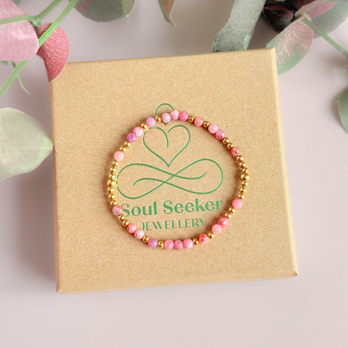 Dainty, minimalist gold vermeil and pink tourmaline October birthstone stacking bracelet. Made with 4mm faceted pink tourmaline beads and 3mm gold vermeil round beads. Elasticated for comfort. Pictured on top of the gift box