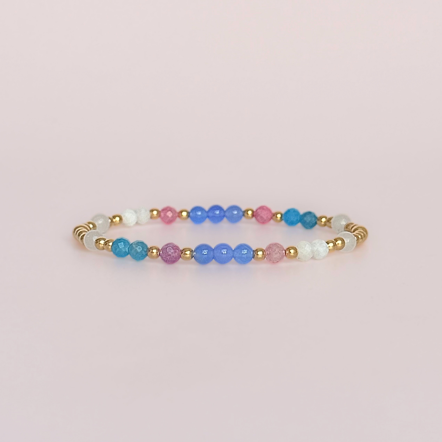 ‘Santorini' gold vermeil dainty beaded bracelet with pink tourmaline, rainbow moonstone, blue agate, apatite and white jade. Made with round 3mm gold vermeil beads and 4mm smooth and faceted round crystal gemstone beads. Pictured against a pink background