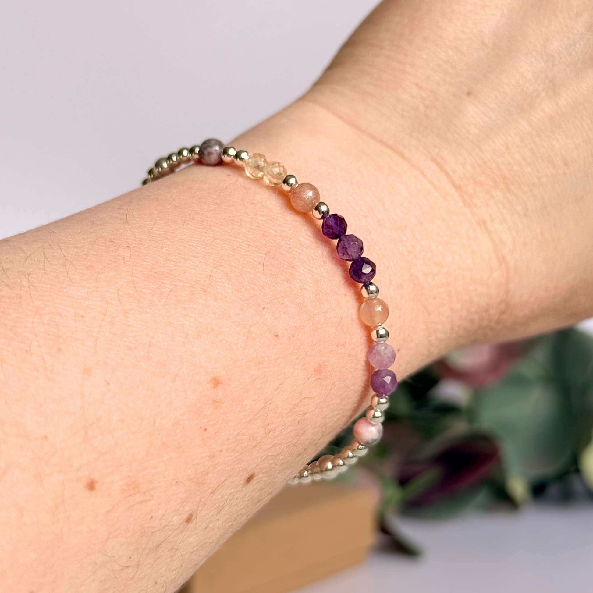 Dainty sterling silver crystal bracelet featuring five crystals, in 4mm faceted and smooth round style, each believed to help with menopause symptoms. Featuring amethyst, citrine, lepidolite, peach moonstone and pink zebra jasper. Picture being worn.