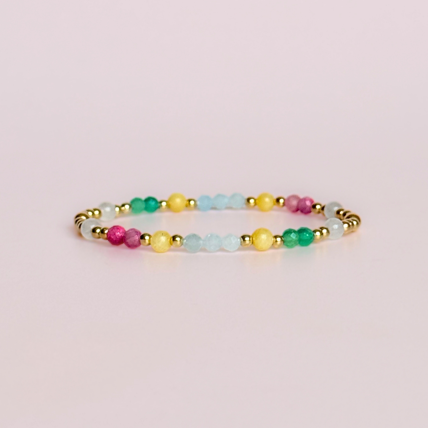'Amalfi Coast' gold vermeil dainty beaded bracelet with green agate, yellow calcite, pink tourmaline, aquamarine and moonstone. Made with round 3mm gold vermeil beads and 4mm smooth and faceted round crystal gemstone beads. Pictured against a pink background
