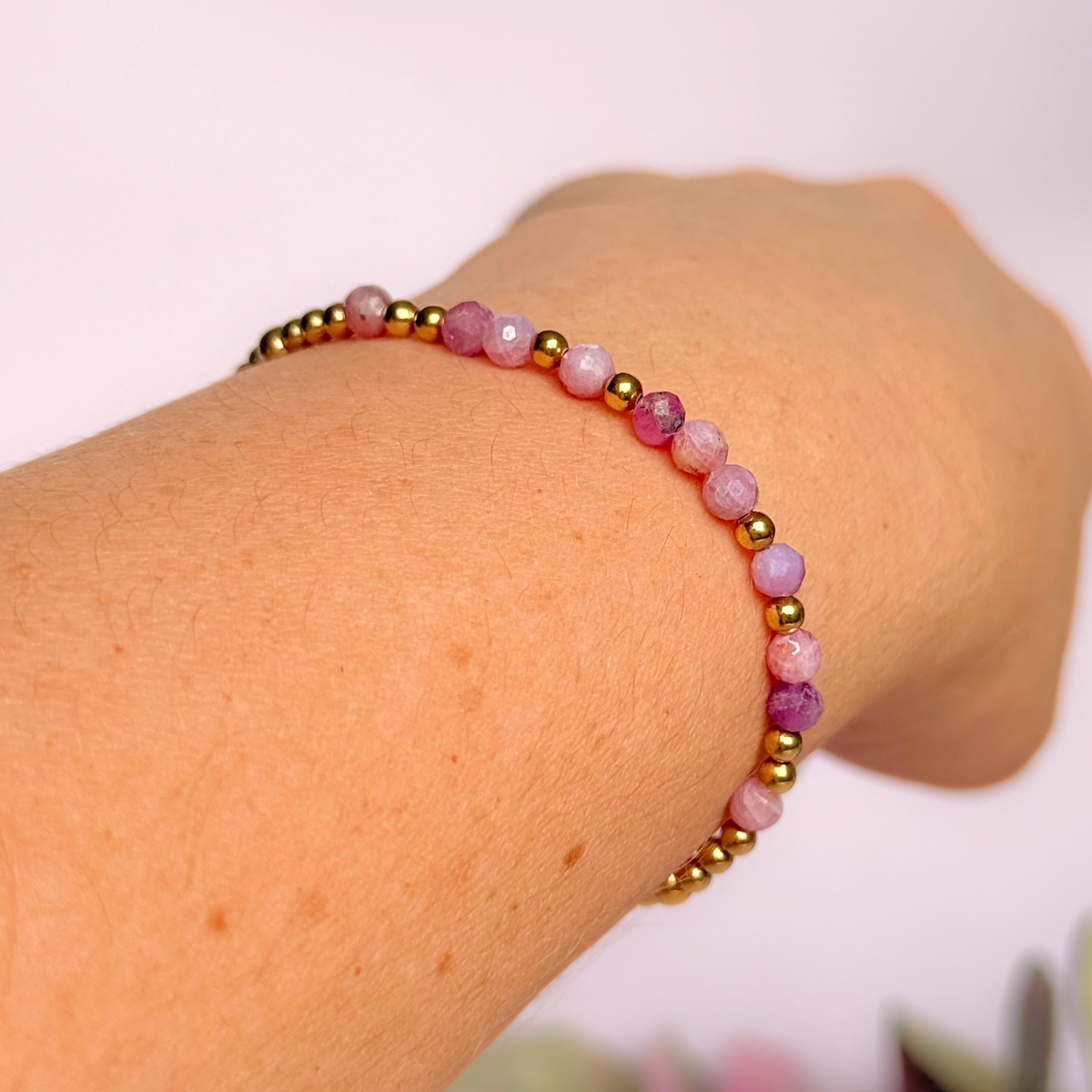 Dainty, minimalist gold vermeil and pink tourmaline October birthstone stacking bracelet. Made with 4mm faceted pink tourmaline beads and 3mm gold vermeil round beads. Elasticated for comfort. Pictured being worn at an angle