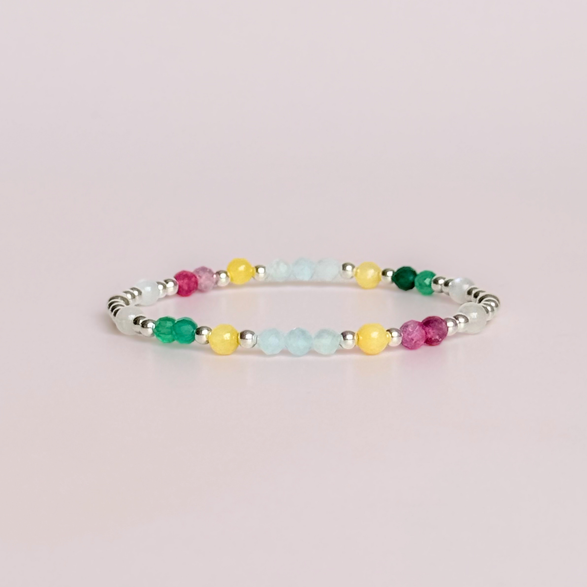 'Amalfi Coast' sterling silver dainty beaded bracelet with green agate, yellow calcite, pink tourmaline, aquamarine and moonstone. Made with round 3mm sterling silver beads and 4mm smooth and faceted round crystal gemstone beads. Pictured against a pink background