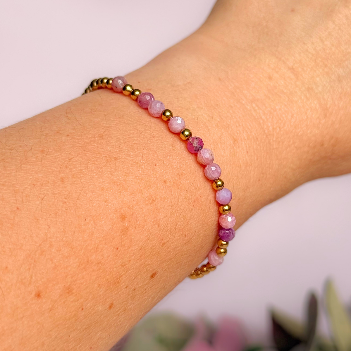 Dainty, minimalist gold vermeil and pink tourmaline October birthstone stacking bracelet. Made with 4mm faceted pink tourmaline beads and 3mm gold vermeil round beads. Elasticated for comfort. Pictured being worn