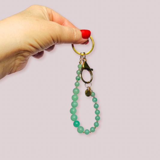 Frosted green aventurine breath work beads on a gold keychain/bag charm. For the 4-7-8 counted breathing method.