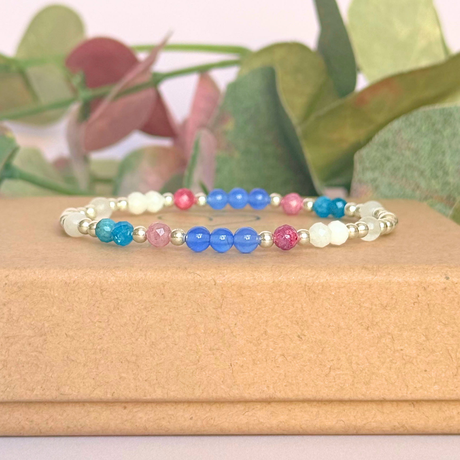 ‘Santorini' sterling silver dainty beaded bracelet with pink tourmaline, rainbow moonstone, blue agate, apatite and white jade. Made with round 3mm sterling silver beads and 4mm smooth and faceted round crystal gemstone beads. Pictured on the gift box, from the side
