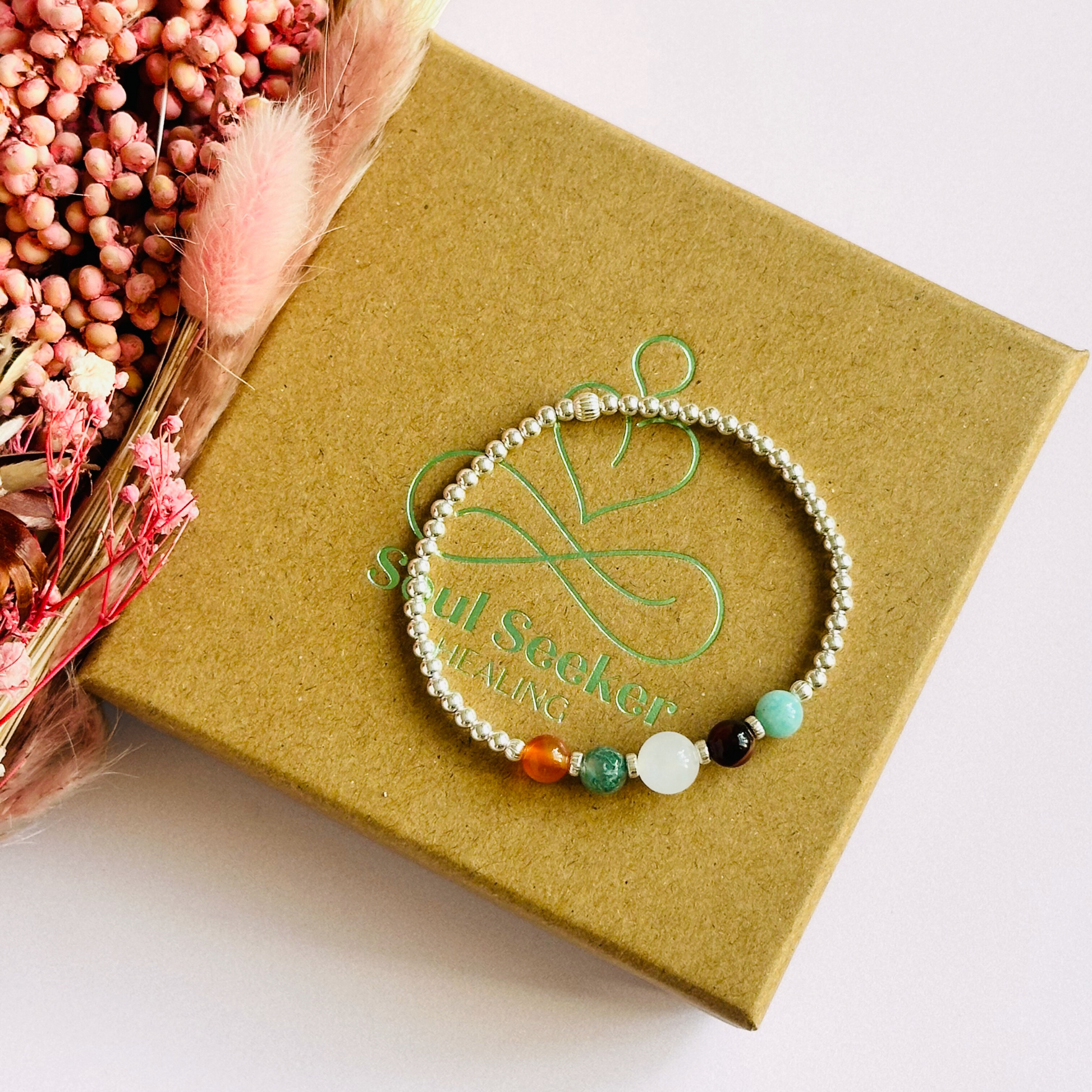 This sterling silver Virgo bracelet is made with a selection of five healing crystals all believed to resonate with the Virgo zodiac sign. The central bead is 8mm, the other four are 6mm. On an elasticated band of 3mm sterling silver beads with corrugated accent beads. Featuring amazonite, carnelian, moonstone, moss agate and sardonyx.