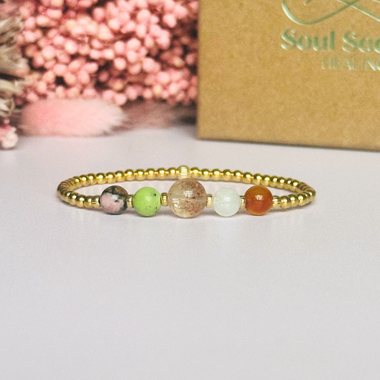 This gold vermeil Cancer bracelet is made with a selection of five healing crystals all believed to resonate with the Cancer zodiac sign. The central bead is 8mm, the other four are 6mm. On an elasticated band of 3mm gold vermeil beads with corrugated accent beads. Featuring chrysoprase, rhodonite, sunstone, moonstone and carnelian.