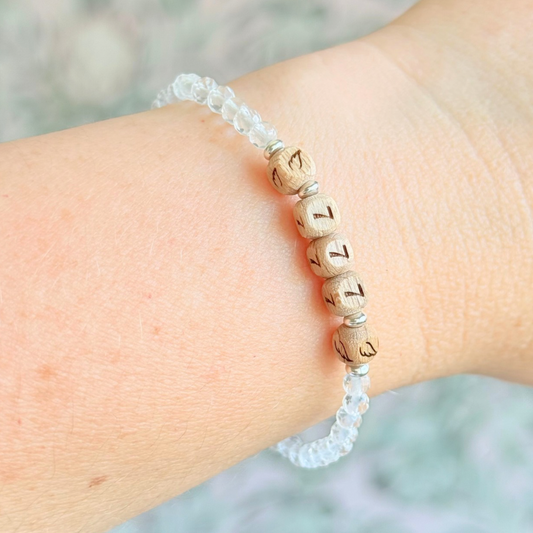 Bracelet featuring engraved wooden 777 angel number and wing beads, on the band of 4mm faceted clear quartz round crystal gemstone beads. Finished with your choice of gold vermeil, sterling silver or rose gold vermeil accent beads.