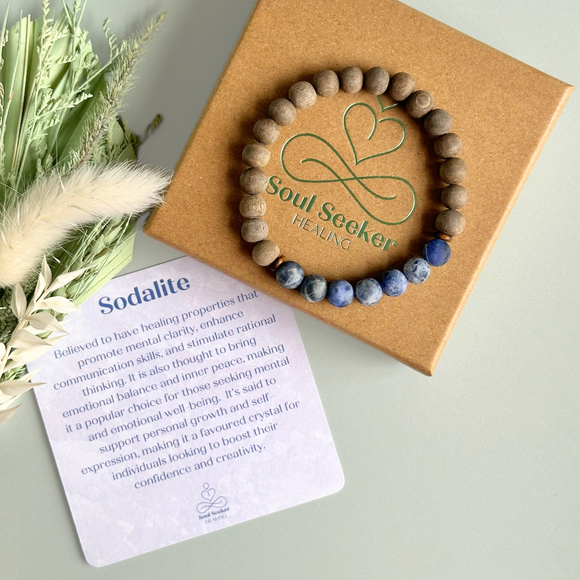 Mens crystal healing bracelet featuring 8mm frosted sodalite beads, grey wood beads and sandalwood spacer beads.