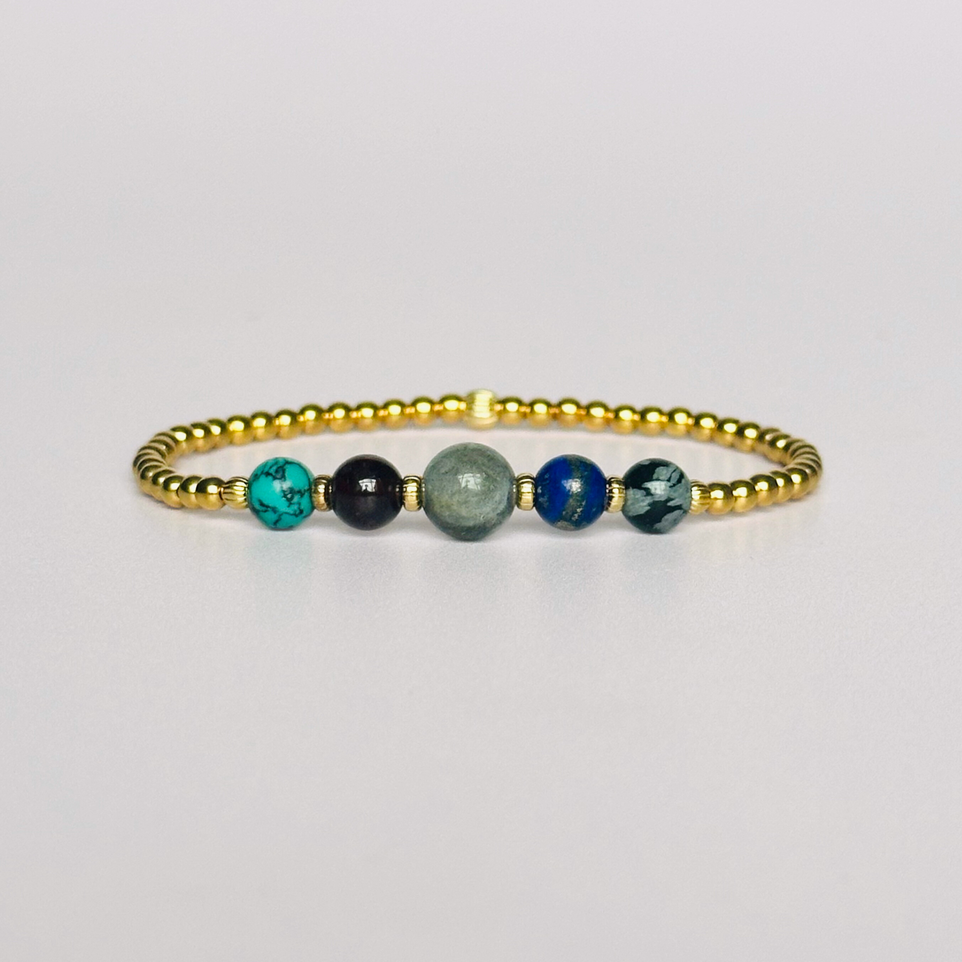 This gold vermeil Sagittarius bracelet is made with a selection of five healing crystals all believed to resonate with the Sagittarius zodiac sign. The central bead is 8mm, the other four are 6mm. On an elasticated band of 3mm gold vermeil beads with corrugated accent beads. Featuring garnet, labradorite, lapis lazuli, snowflake obsidian and turquoise.