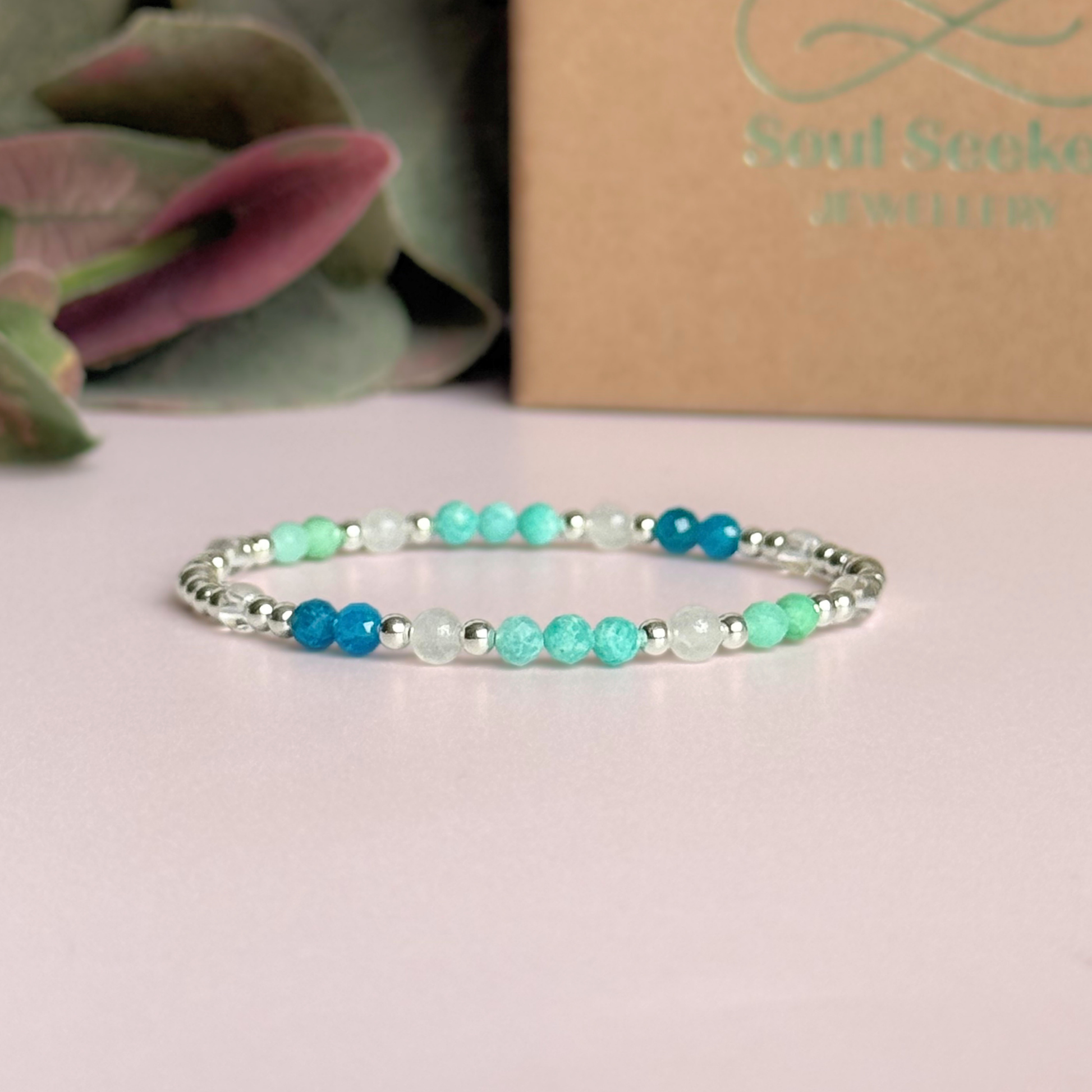 ‘Caribbean Dream' sterling silver dainty beaded bracelet with white jade, chrysoprase, amazonite, apatite and clear quartz. Made with round 3mm sterling silver beads and 4mm smooth and faceted round crystal gemstone beads. Pictured in front of the gift box 