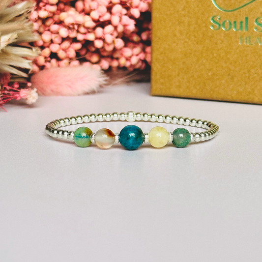 This sterling silver Gemini bracelet is made with a selection of five healing crystals all believed to resonate with the Gemini zodiac sign. The central bead is 8mm, the other four are 6mm. On an elasticated band of 3mm sterling silver beads with corrugated accent beads. Featuring chrysocolla, dendritic agate, apatite, yellow calcite and moss agate.