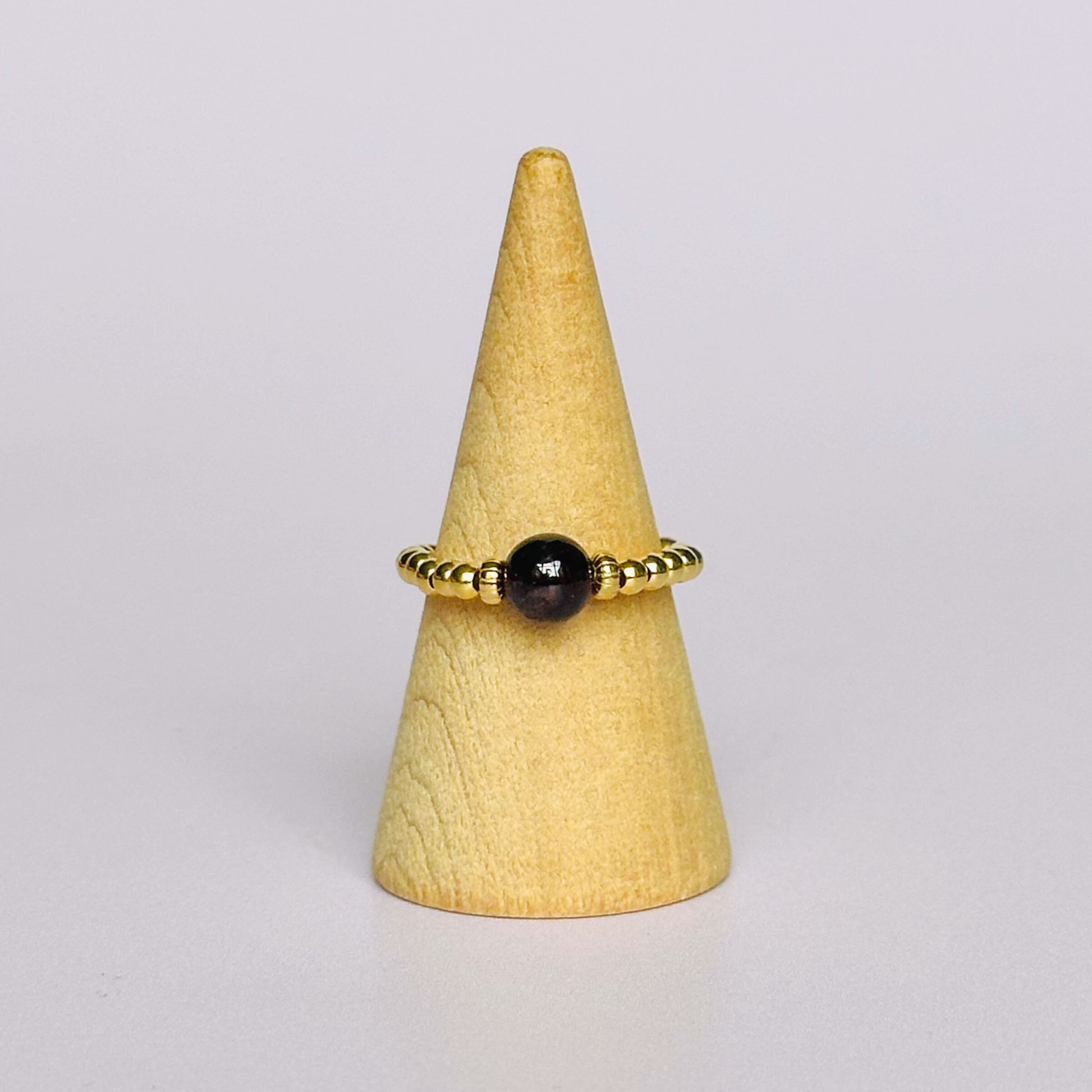 Gold vermeil garnet ring featuring a 6mm smooth round garnet bead on a elasticated ring band of 2.5mm gold vermeil beads.