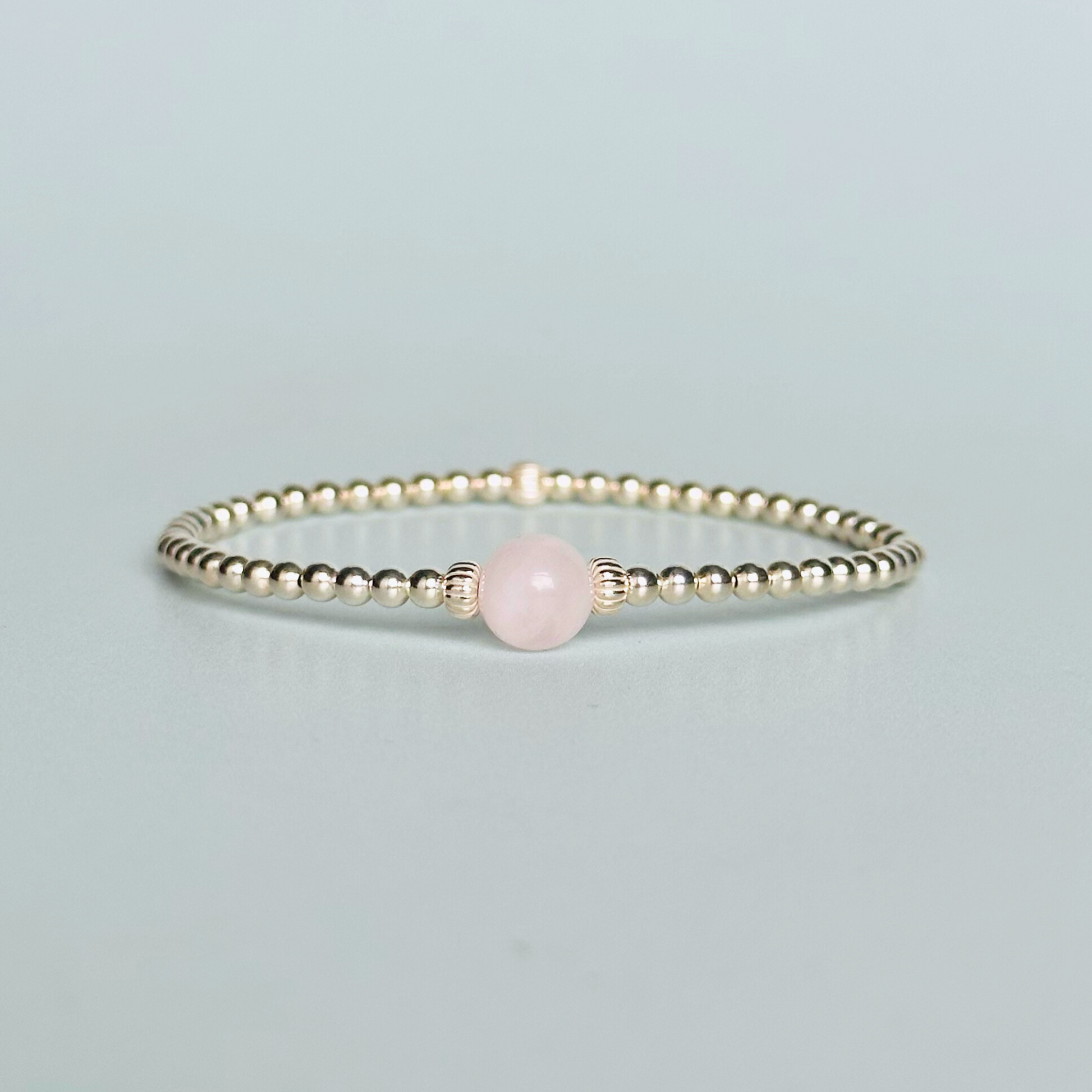 sterling silver rose quartz  bracelet features an ethically mined 8mm rose quartz bead, flanked by corrugated rondelle beads on a band of 3mm sterling silver beads. A bracelet to promote self love and self-confidence.
