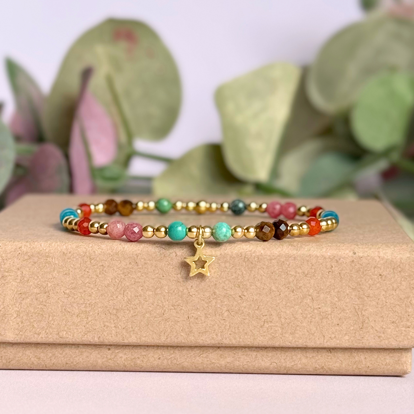 'Hot girl summer' gold vermeil dainty beaded bracelet with tigers eye, turquoise, apatite, carnelian and rhodochrosite. With a beautiful open star charm.Made with round 3mm gold vermeil beads and 4mm smooth and faceted round crystal gemstone beads. Pictured from the side, on top of the gift box.