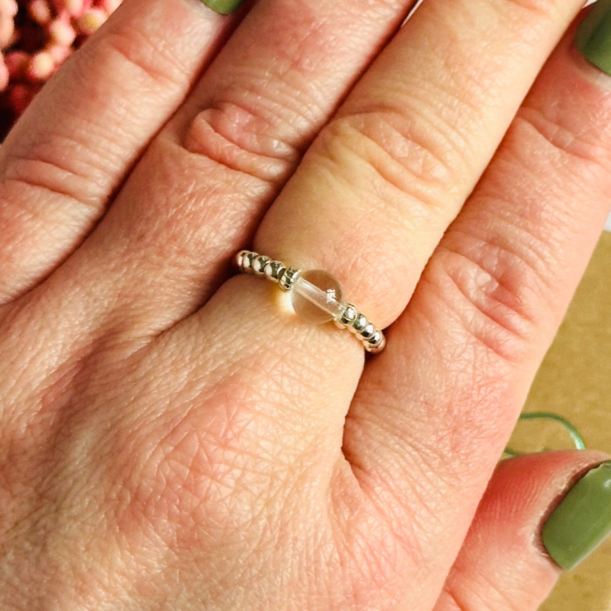 This sterling silver clear quartz ring features a 6mm round ethically sourced clear quartz bead, surrounded by sterling silver corrugated rondelle beads and delicate 2.5mm sterling silver beads. April birthstone.
