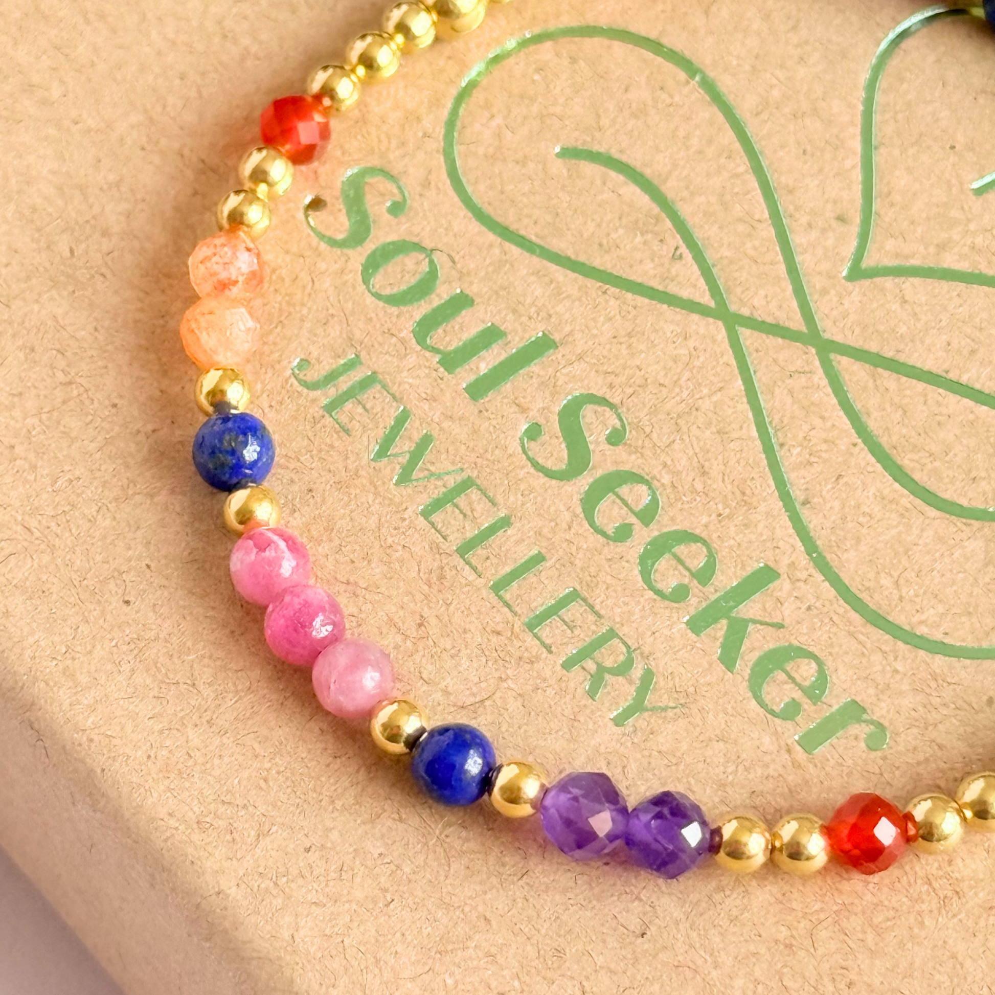 ‘Arabian Sunset' gold vermeil dainty beaded bracelet with pink tourmaline, sunstone, carnelian, lapis lazuli and amethyst. Made with round 3mm gold vermeil beads and 4mm smooth and faceted round crystal gemstone beads. Pictured on top of the gift box, close up.