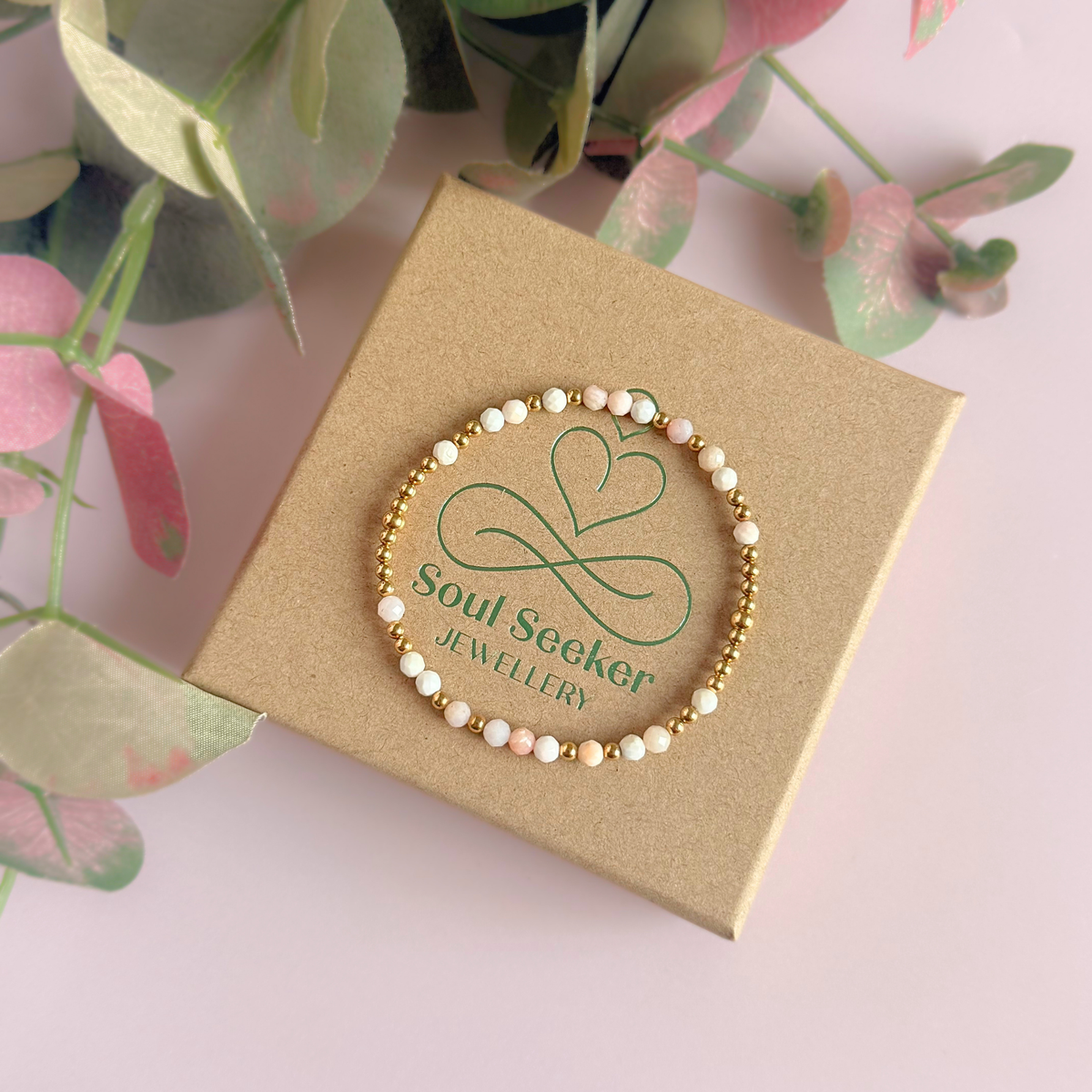 Dainty, minimalist gold vermeil and pink opal October birthstone stacking bracelet. Made with 4mm faceted pink opal beads and 3mm gold vermeil round beads. Elasticated for comfort. Pictured on top of the box