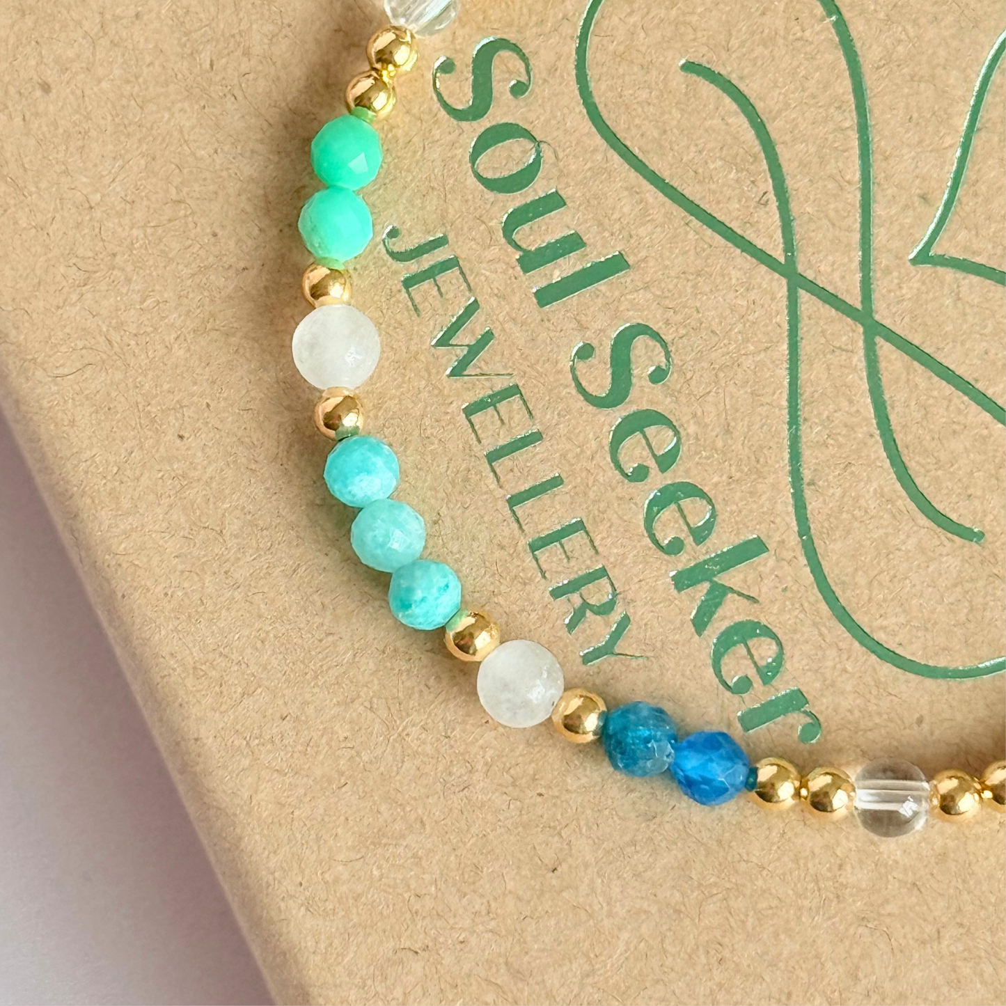 ‘Caribbean Dream' gold vermeil dainty beaded bracelet with white jade, chrysoprase, amazonite, apatite and clear quartz. Made with round 3mm gold vermeil beads and 4mm smooth and faceted round crystal gemstone beads. Pictured on the gift box, close up