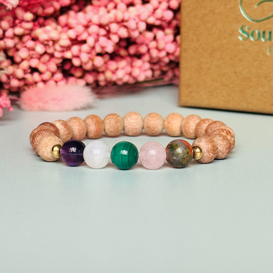 Essential oil diffuser bracelet featuring five crystal beads, all thought to aid in having a healthy pregnancy. Featuring unakite, rose quartz, amethyst, malachite and moonstne with raw rosewood beads that can act as a diffuser for essential oils.