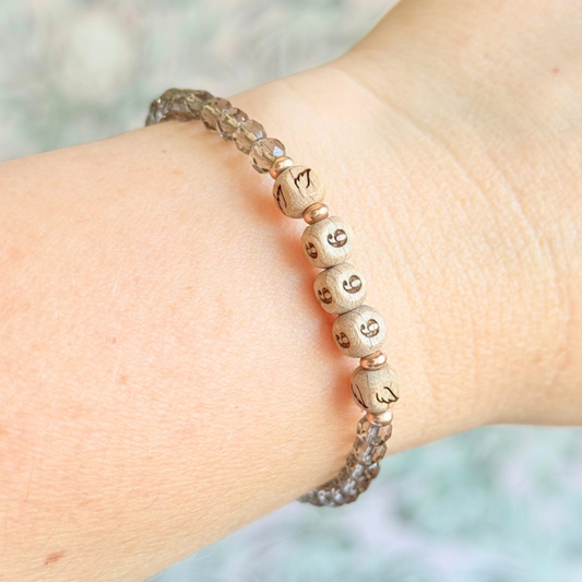 Bracelet featuring engraved wooden 999 angel number and wing beads, on the band of 4mm faceted smoky quartz round crystal gemstone beads. Finished with your choice of gold vermeil, sterling silver or rose gold vermeil accent beads.