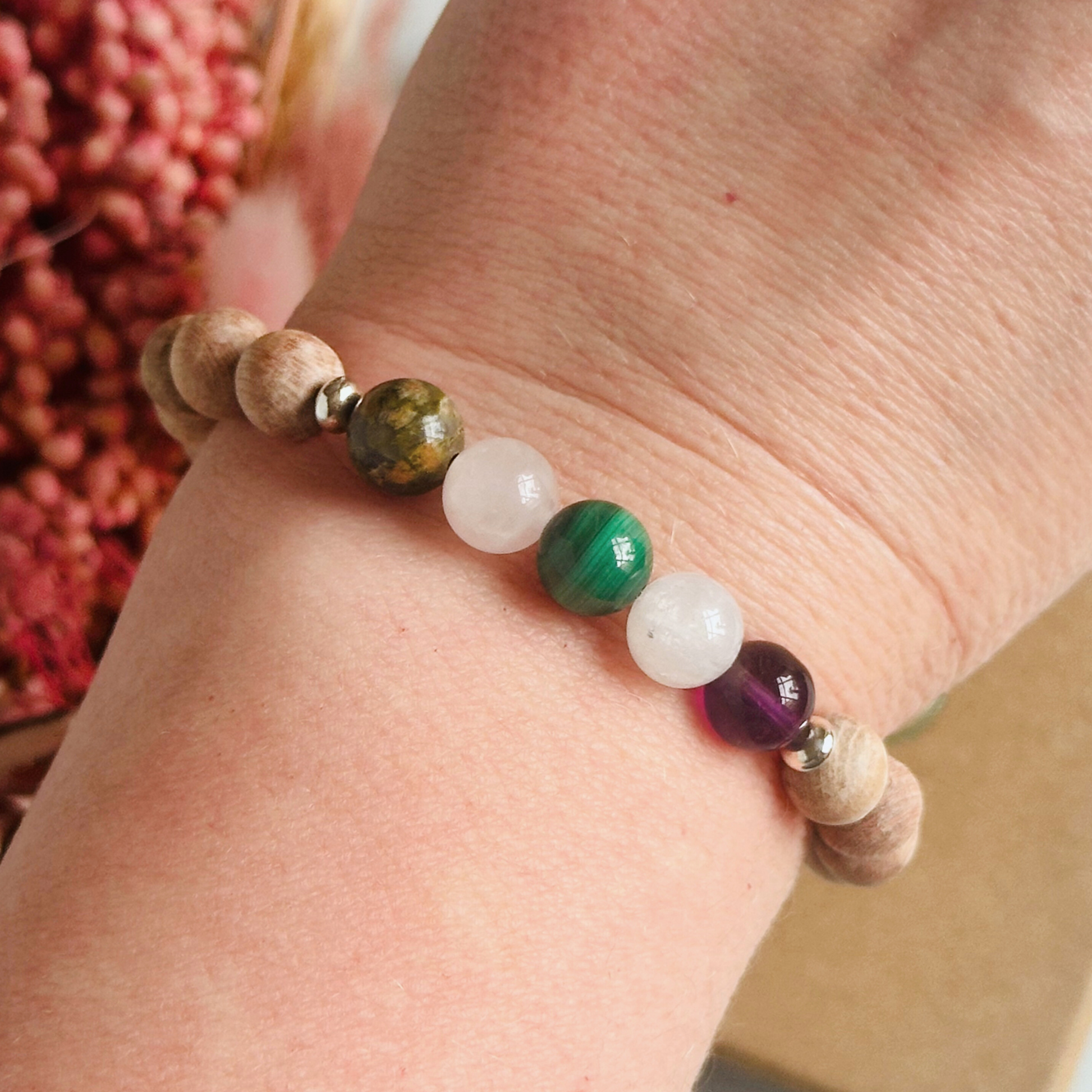 Essential oil diffuser bracelet featuring five crystal beads, all thought to aid in having a healthy pregnancy. Featuring unakite, rose quartz, amethyst, malachite and moonstne with raw rosewood beads that can act as a diffuser for essential oils.